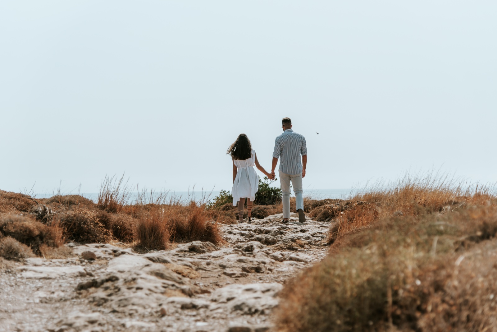 Couple walking hand to hand near to the beach 